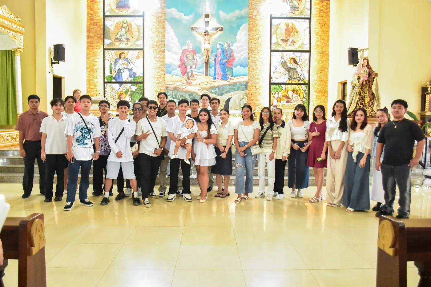 Family and guests posing for a group photo inside a church after a baptism