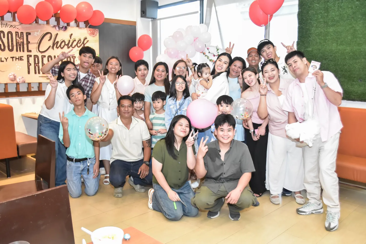 Big group of guests posing together and flashing peace signs at a birthday celebration at a restaurant in Bacoor, Cavite