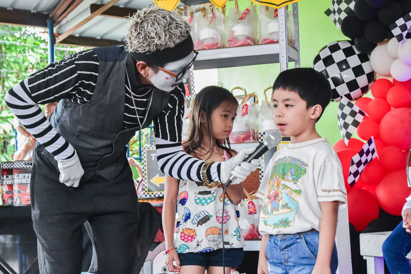 Mime performer playing a game with two children at a themed kids party